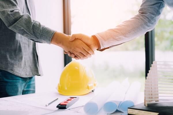 Two people shake hands after discussing construction worker interview questions