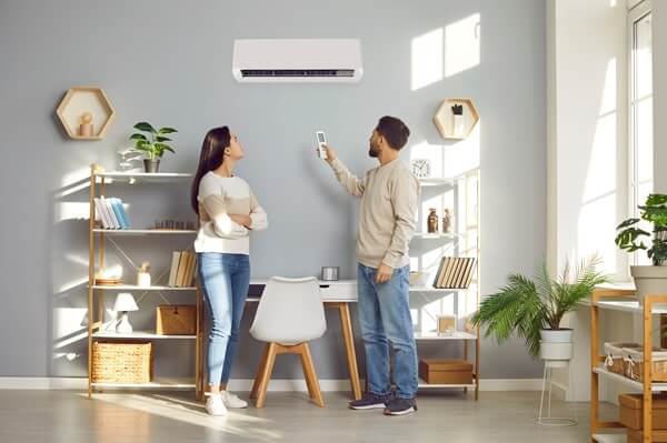A couple uses a smart remote to program climate control on their ductless HVAC