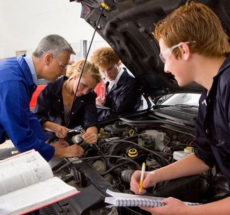 Thumbnail of an automotive instructor shows students the engine under the hood of a car